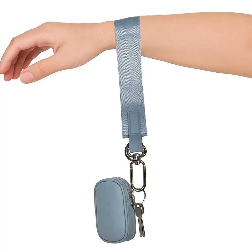A hand is holding a blue nylon strap wristlet keychain attached to a small pouch.
