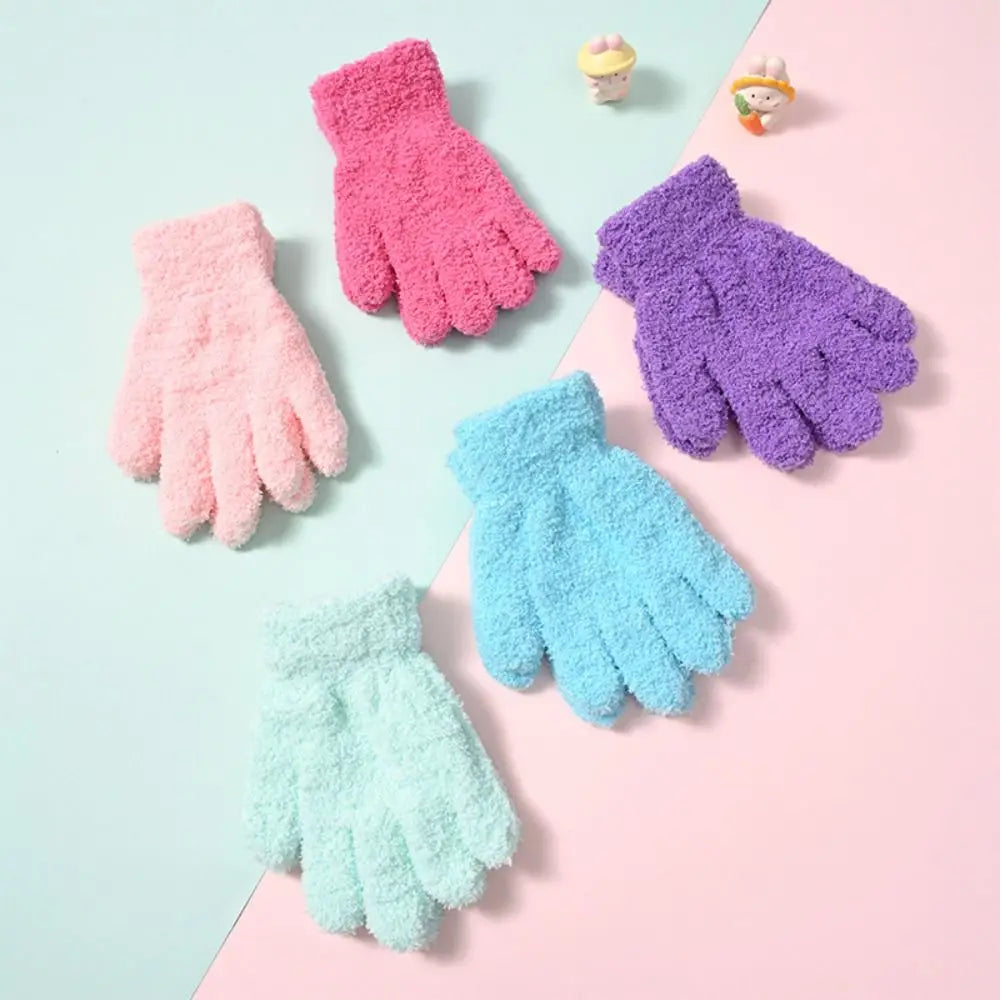 A collection of colorful plush winter gloves in shades of pink, purple, and blue are displayed on a light background.