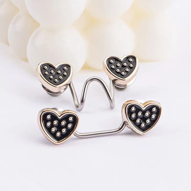 Silver heart-shaped buttons with black studs arranged in a cluster on a white background.