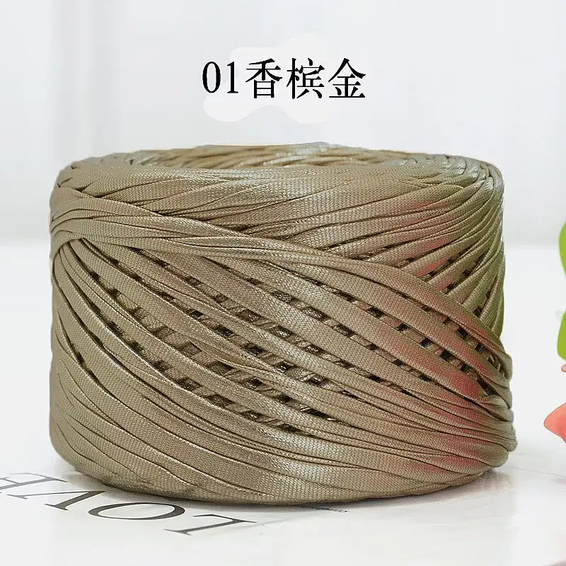 A ball of metallic flat ribbon yarn used for crochet and knitting.