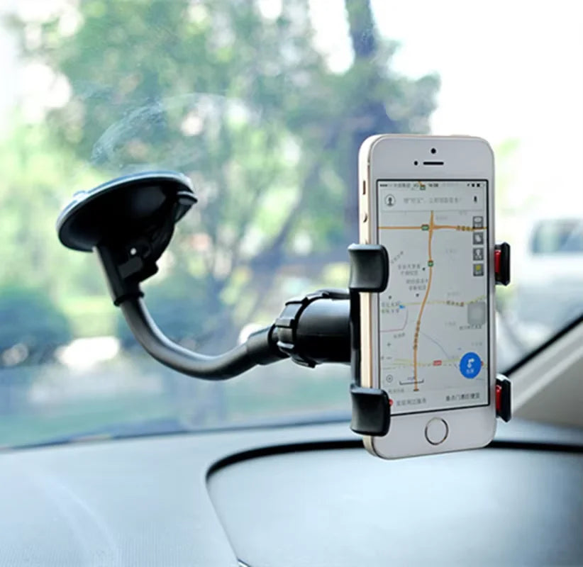 Un smartphone est monté sur la vitre d'une voiture avec un support à ventouse pour la navigation.