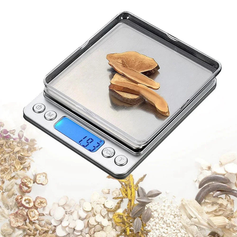 A silver digital pocket scale with a tray is shown next to dried herbs and seeds.