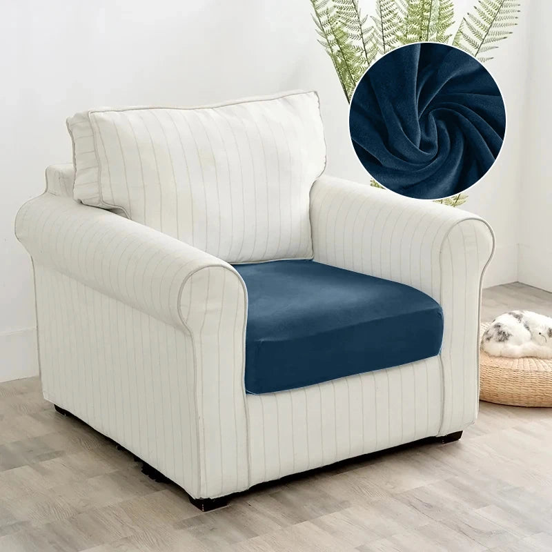 A cream upholstered armchair with navy blue seat cover and a dark blue decorative throw.