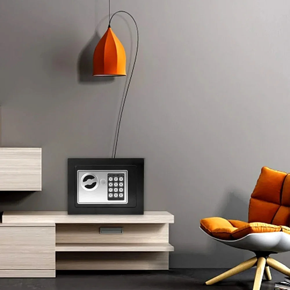 Une lampe pendent orange est suspendue au-dessus d'une boîte de sécurité numérique noire sur une armoire en bois clair.