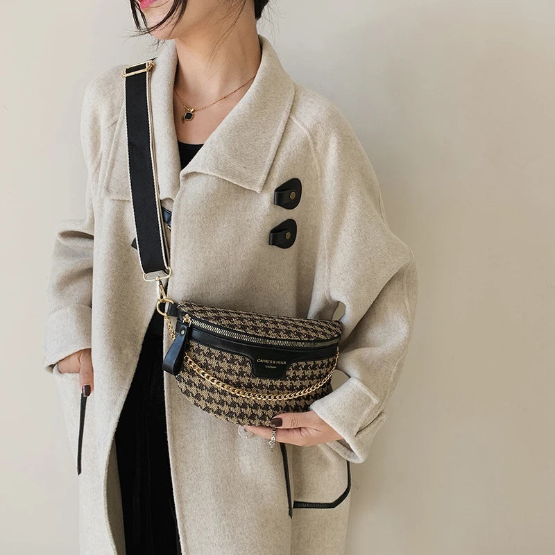 Eine Frau trägt einen beige Mantel und ein schwarzes Oberteil und hält eine Leopardenmuster-Crossbodytasche mit goldfarbenem 