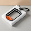 A white organizer tray holds a black cable tie with an orange tip and a silver carabiner clip.