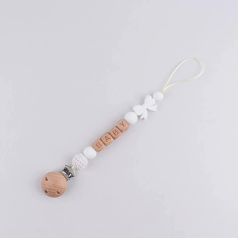 A personalized silicone pacifier clip with a name and anti-drop lanyard on a white background.