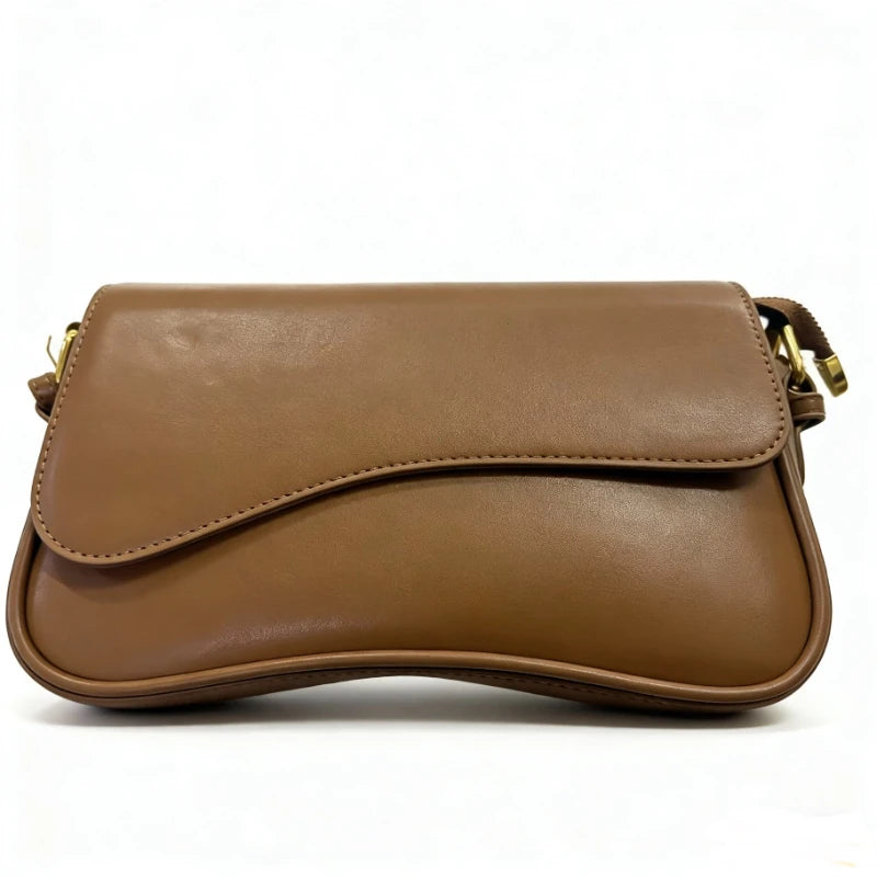 A tan vintage leather crossbody bag with a flap closure shown from the side.