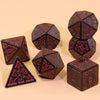 A set of multi-sided polyhedral dice in dark red and black colors displayed on a light background.
