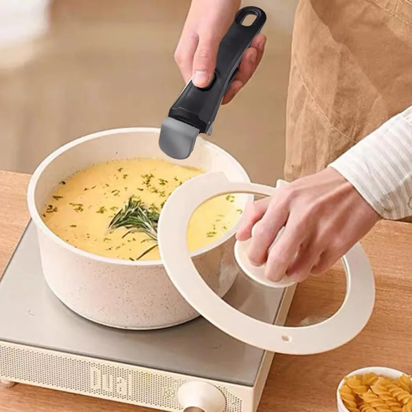 A hand is using a white handle to lift a yellow liquid from a cooking pot on a dual electric cooktop.