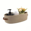 A woven cotton rope storage basket with a black lid and a white roll of paper inside.