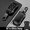 A black zinc alloy key fob case for a Chevy Silverado or GMC Sierra truck is shown with its attached key.
