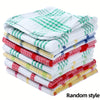 A stack of plaid kitchen towels in various green, red, and white patterns.