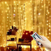 A hand holds a remote control near a display of USB LED curtain string lights with various colored lights.