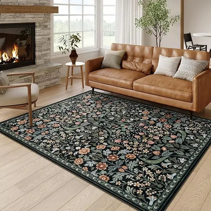 A vintage floral area rug featuring dark green and pink botanical patterns in a living room setting.