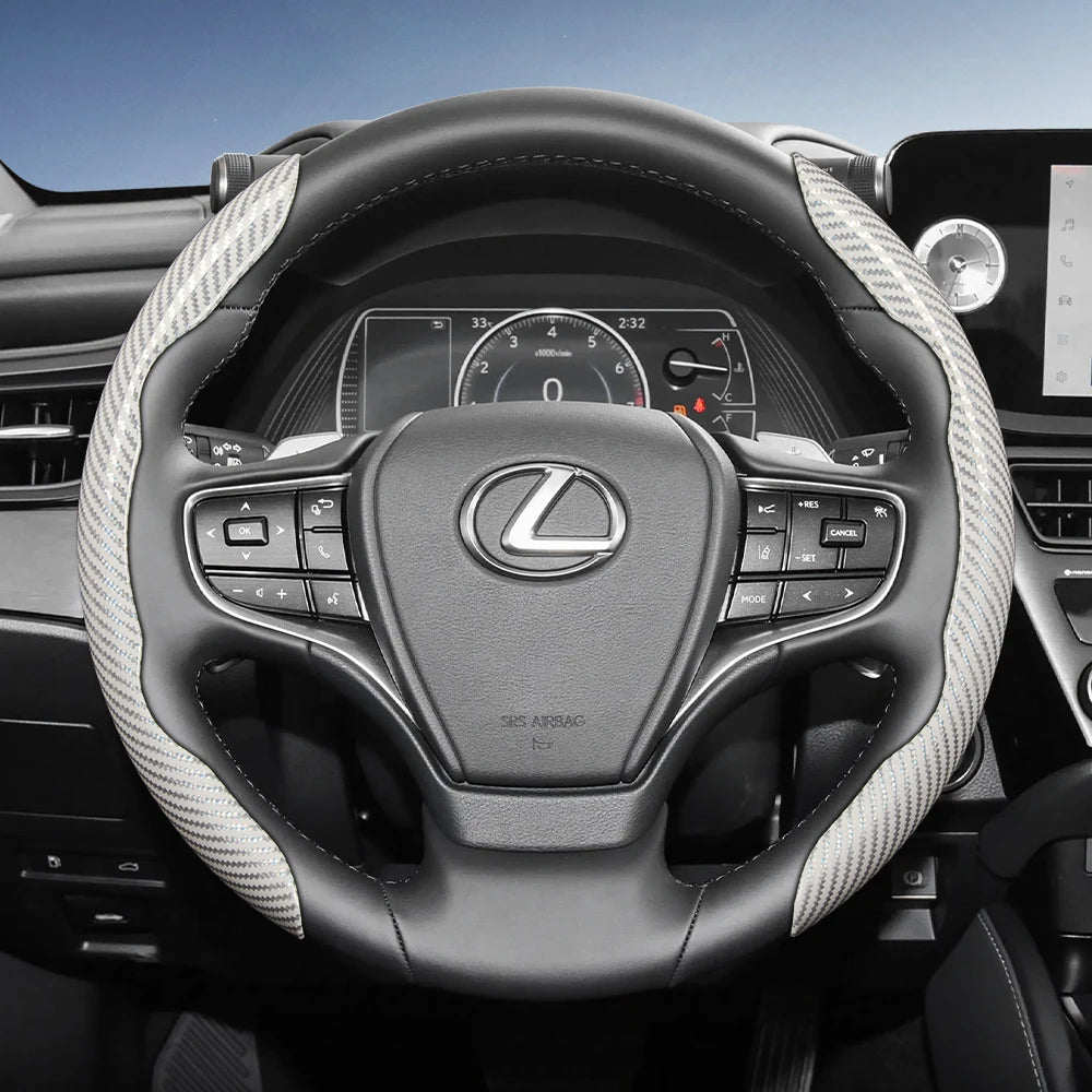 A black steering wheel with a carbon fiber texture cover and controls in a car interior.