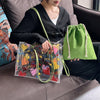 A woman holds a clear transparent tote bag with an inner pouch and a green fabric drawstring bag on a brown couch.