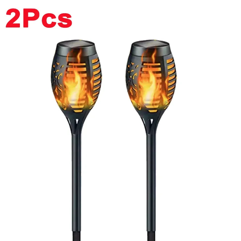 A pair of black solar flame torch lights with glowing orange flames.