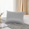 Housse de couette en soie mulberry naturelle gris clair posée sur un tissu gris texturé près d'une fenêtre.