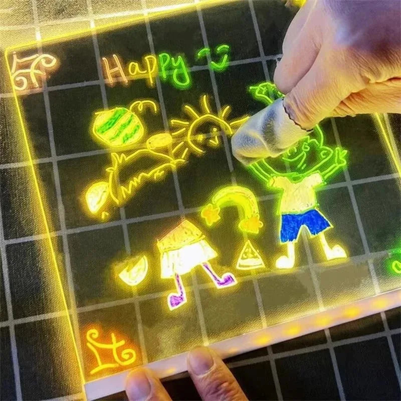 A hand draws a happy sun and figure on a glowing LED drawing board with colored pens.