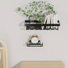 A black adhesive wall-mounted bathroom organizer set featuring shower shelves and a clock, displayed on a light gray wall.