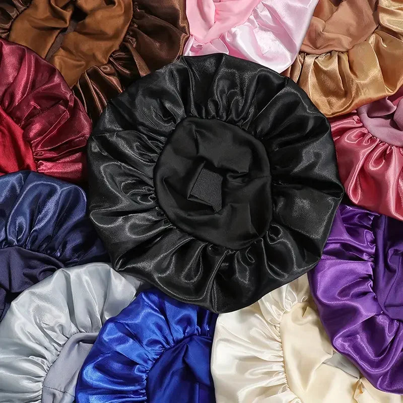 A collection of satin wide brim shower caps in various colors including black, pink, gold, purple, and blue.