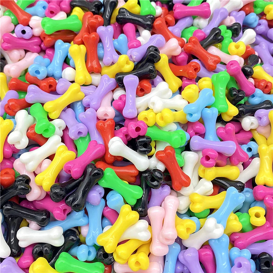 A close-up view of a large pile of colorful bone-shaped acrylic beads for jewelry making