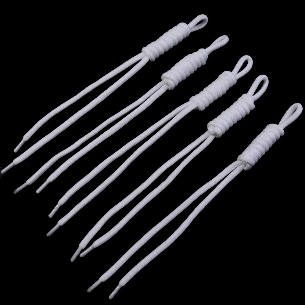 A set of white braided nylon lanyards or keychains arranged diagonally against a black background.