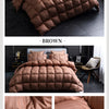 Brown quilted duvet cover and bedding set displayed on a bed.