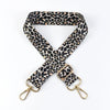 A black and tan leopard print wide adjustable crossbody bag strap.