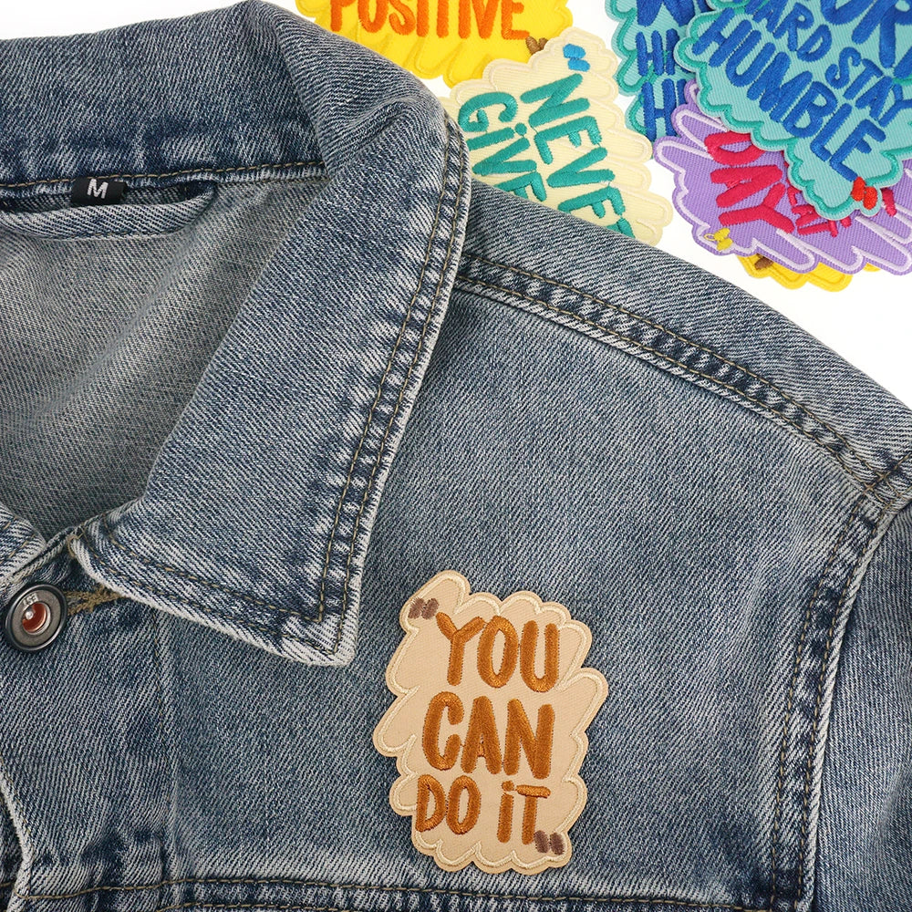 A denim jacket features an embroidered patch that reads You can do it