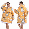 Eine Frau modelliert einen gelb-weißen Patchwork-Fleece-Hoodie mit Hundeprint auf dem Rücken.
