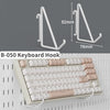 A white keyboard hook shown alongside a full pink and white mechanical keyboard.