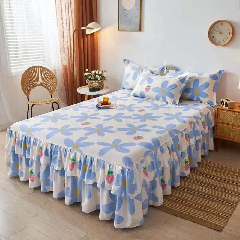Jupe de lit à motifs floraux blancs et bleus avec ourlet froncé, exposée sur un lit.