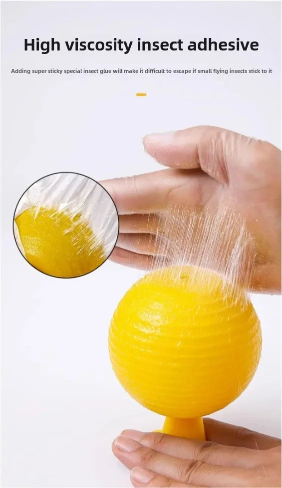 A hand is squeezing a yellow, high-viscosity insect adhesive ball, demonstrating its sticky properties.