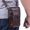 A brown vintage genuine cowhide leather crossbody sling bag worn by a person.