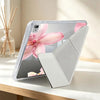 A clear silicone tablet case featuring a pink lily flower design and an integrated pen holder, shown on a wooden surface.