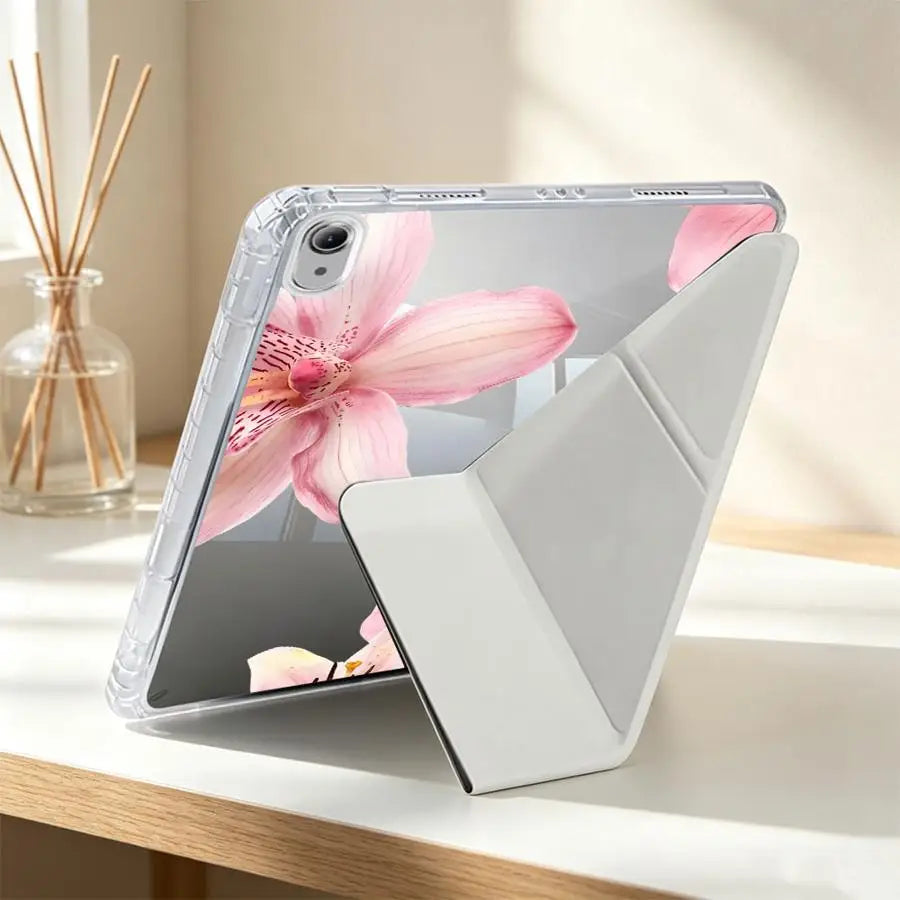 A clear silicone tablet case featuring a pink lily flower design and an integrated pen holder, shown on a wooden surface.