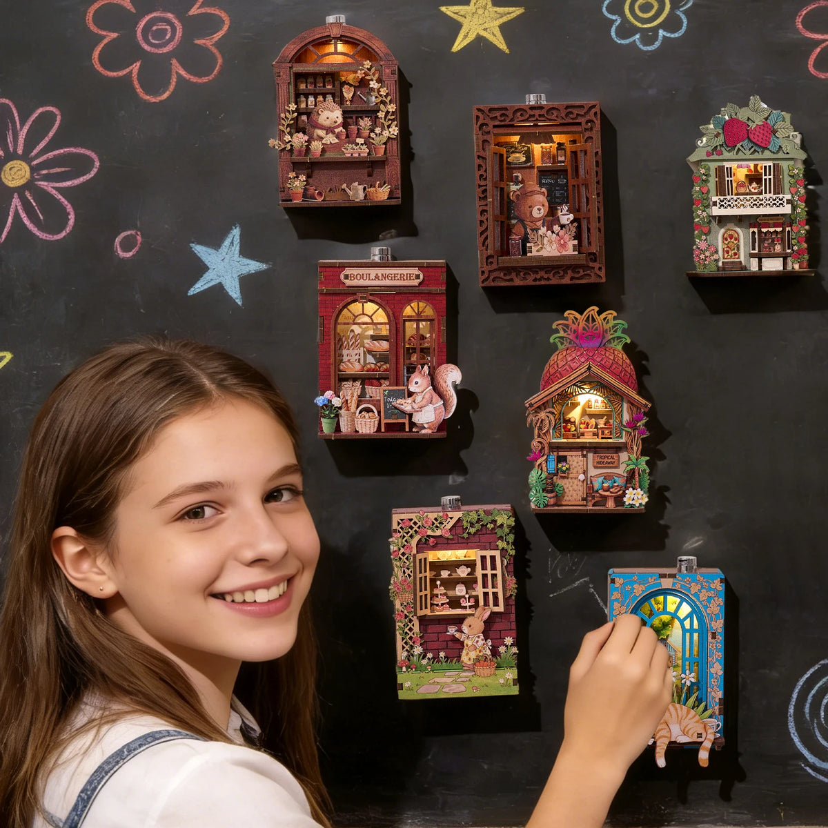 A girl smiles while looking at a display of DIY book nook fridge magnets with LED lighting.