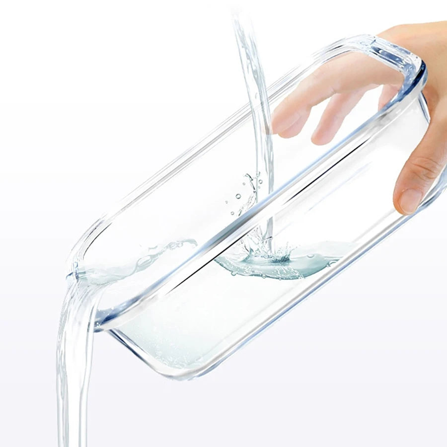 Une main verse de l'eau dans un récipient de conservation alimentaire en verre borosilicate transparent.