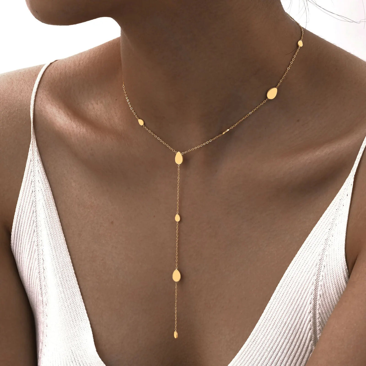 Primer plano de un collar de lazar dorado en capas, usado alrededor del cuello.