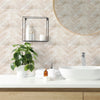 A bathroom vanity featuring a white vessel sink, wooden countertop, and decorative wall tiles with a circular mirror.