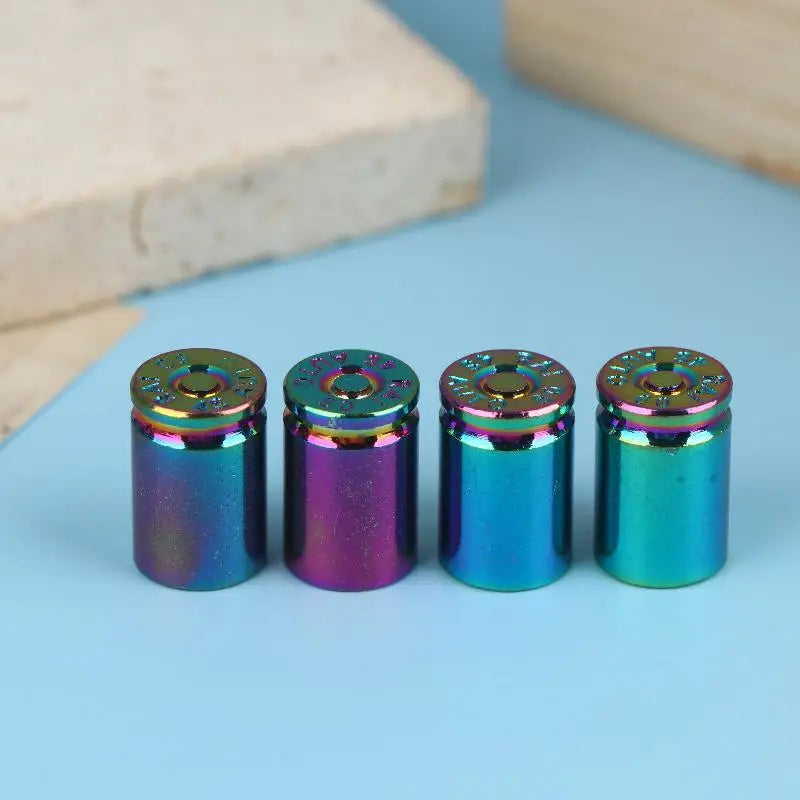 A set of four iridescent bullet shell tire valve stem caps showing various shades of blue, purple, and green.