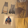 A set of chef aprons in gray and yellow tones, including a full apron and a yellow quilted apron.