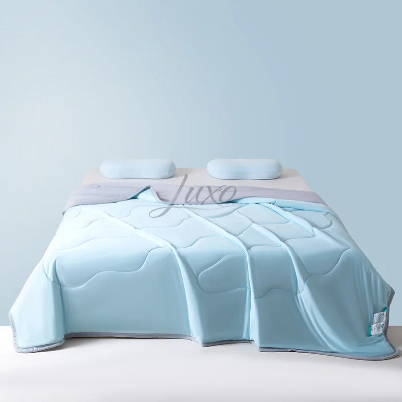 Light blue ice silk cooling blanket folded on a bed with a light purple sheet.