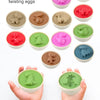 A collection of dinosaur pair twisting eggs in various colors and shapes, displayed on a white background.