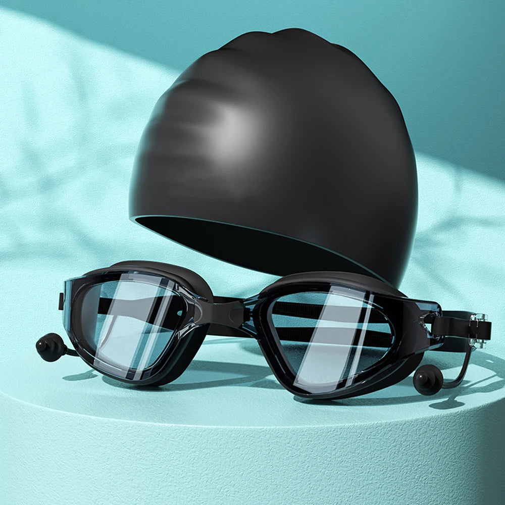 Un par de gafas de natación negras HD antiempañantes con sello de silicona sobre una superficie azul claro.
