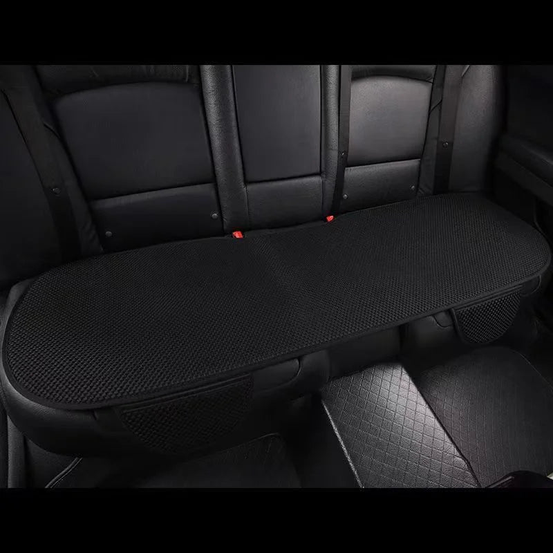 A black car seat cushion with a textured surface is shown inside a vehicle cabin.