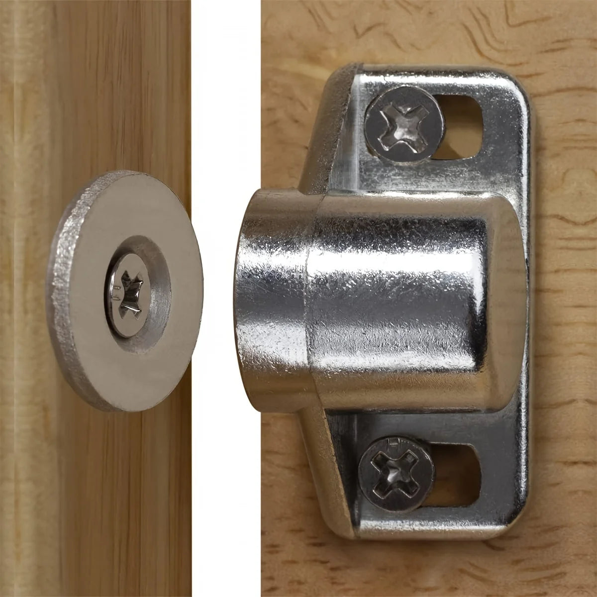 Loquet magnétique argenté installé sur une porte de meuble en bois.
