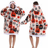 Eine Frau modelliert einen gemütlichen, oversized Fleece-Hoodie aus orange-weißem Halloween-Muster.